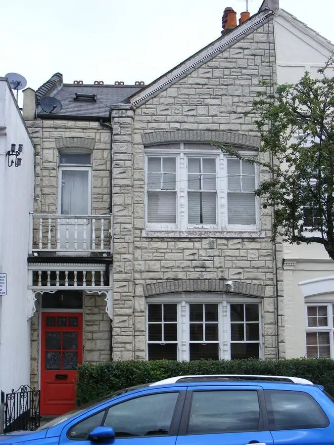 Two-storey house facade with textured pale stone cladding