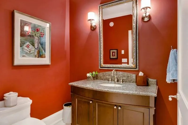 Bathroom with red painted walls and a stone-topped vanity