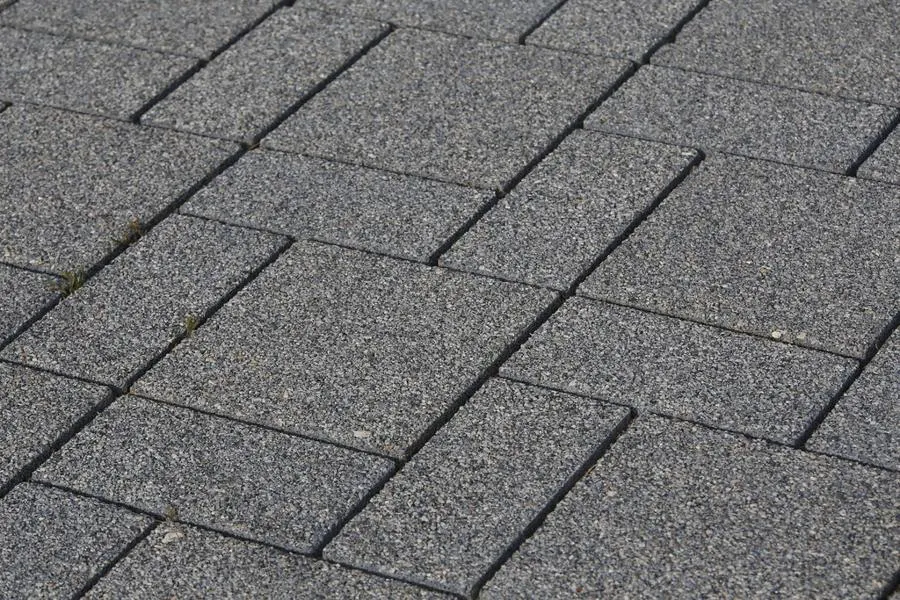 Grey rectangular paving blocks laid in a repeating pattern