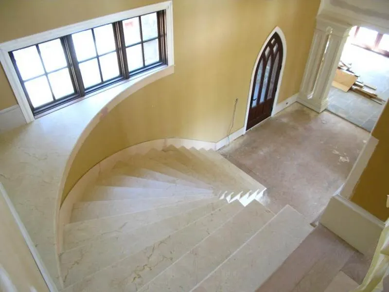 Curved staircase with pale polished stone steps