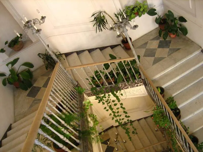 Indoor stone staircase and open landing with white railings