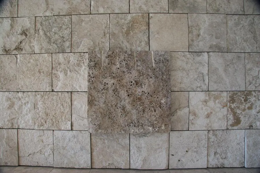 Square beige stone tiles with natural texture and visible joints