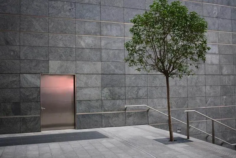 Grey rectangular exterior wall tiles beside steps and a doorway