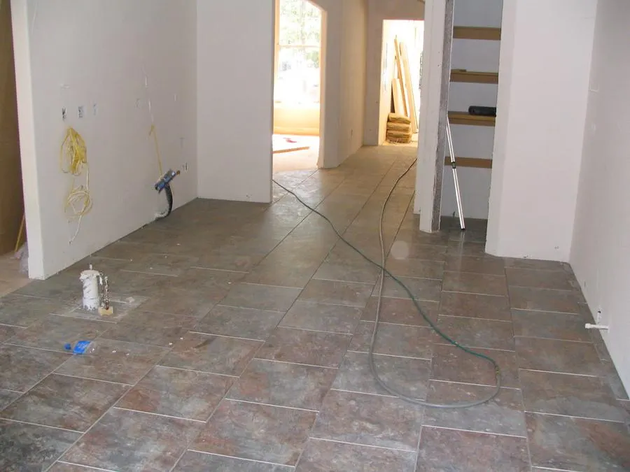 Large stone-pattern floor tiles in a room under renovation