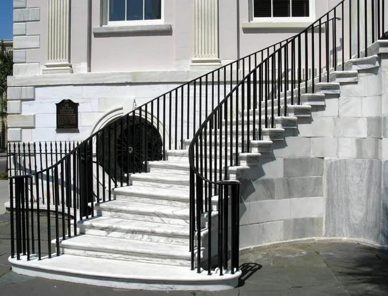 Exterior staircase with pale stone treads and black railings