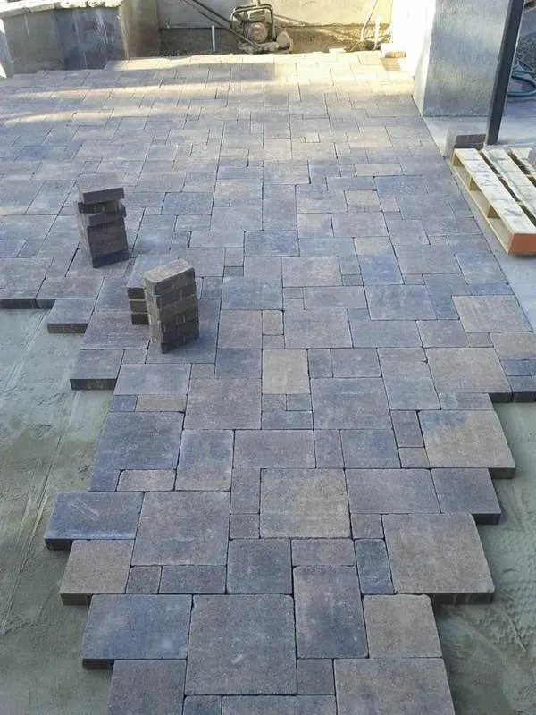 Outdoor paving blocks being laid beside a wall