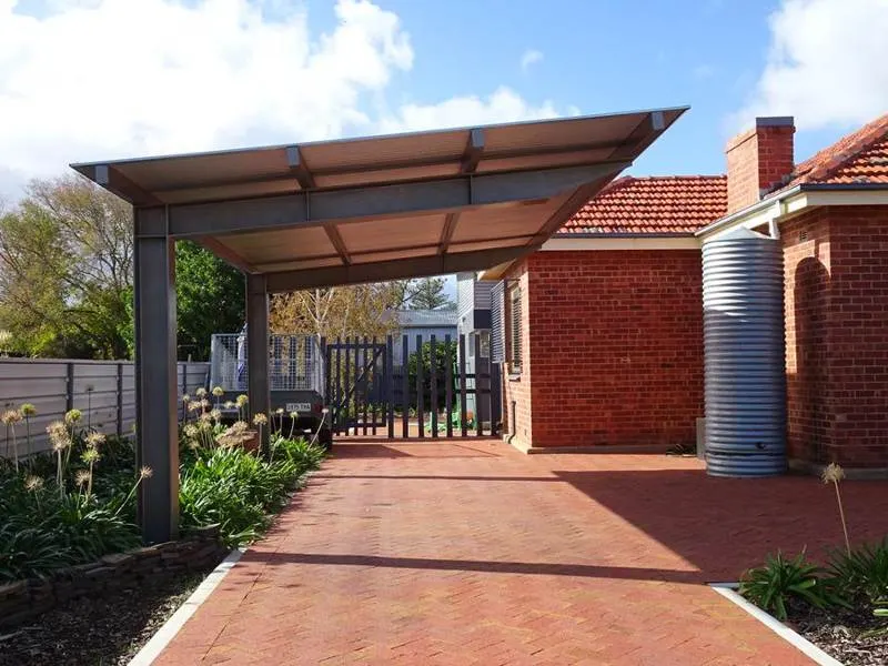 Covered car porch with brick paving and a metal canopy