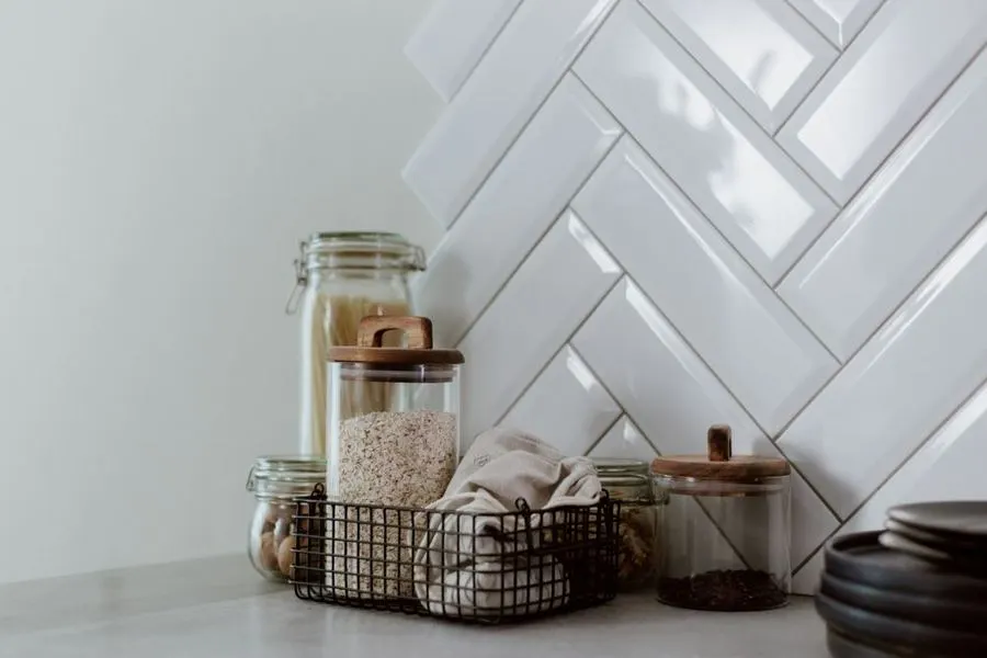 White herringbone tiles behind kitchen accessories