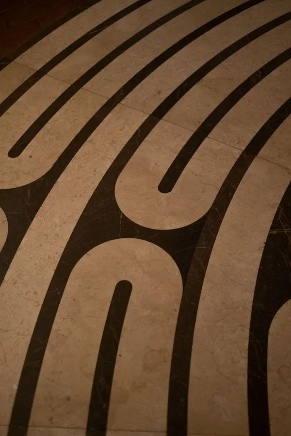 Decorative dark curved pattern on a tan floor
