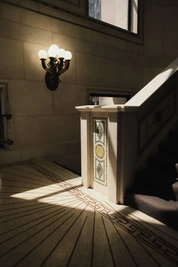 Stair landing with a stone balustrade and decorative wall light