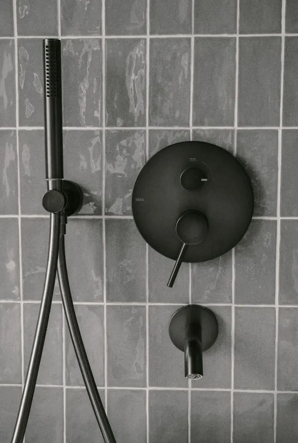 Dark rectangular shower tiles with black shower fittings