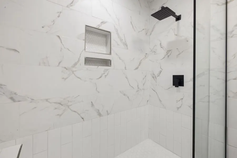 White marble-pattern shower tiles with a recessed niche