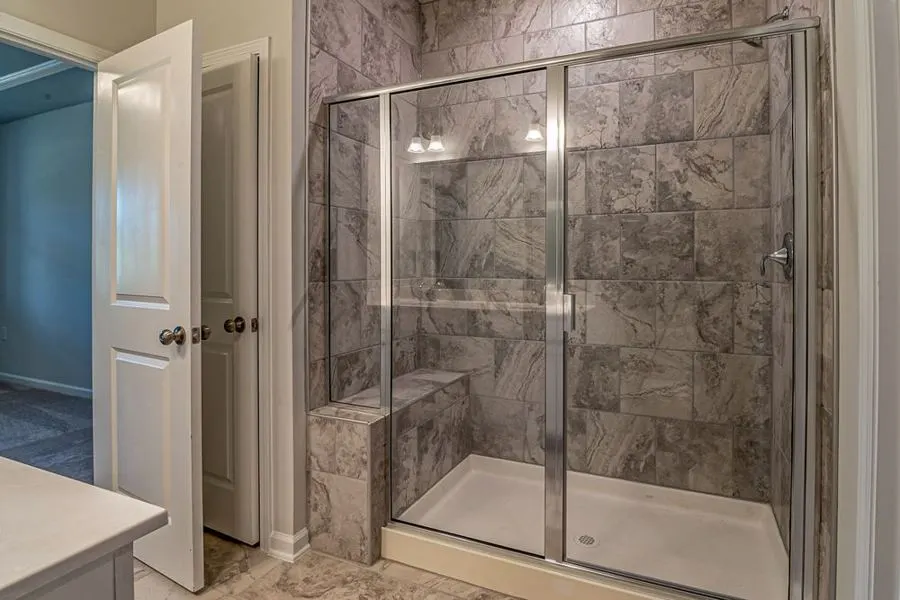 Shower enclosure with stone-pattern tiles and a glass door