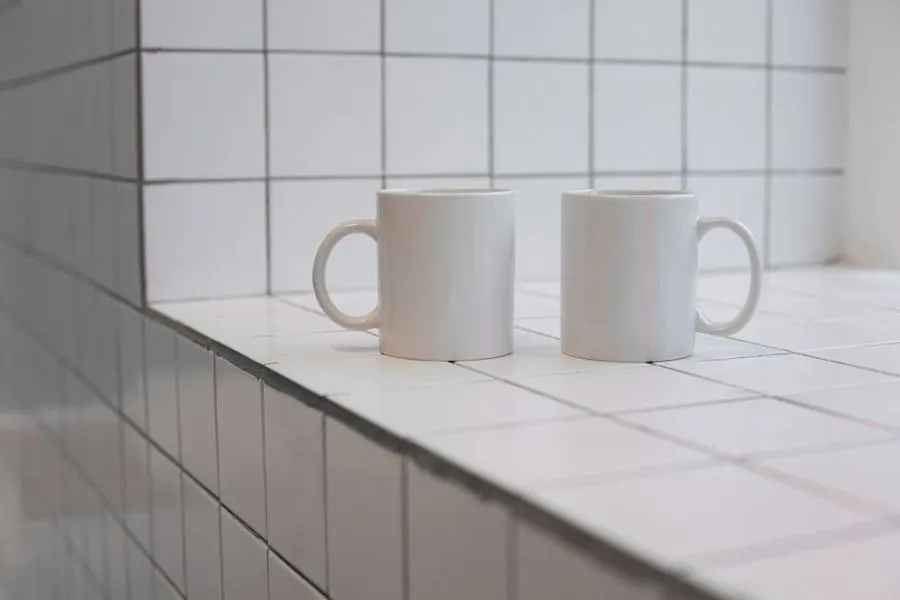 White tiled kitchen counter and backsplash with two mugs