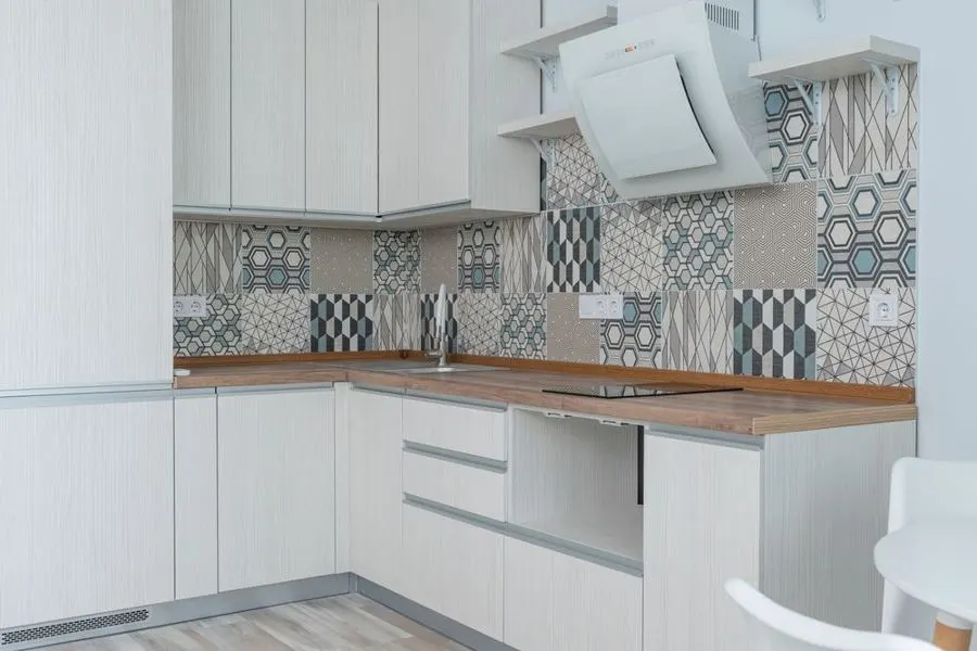 White kitchen with a patchwork patterned backsplash