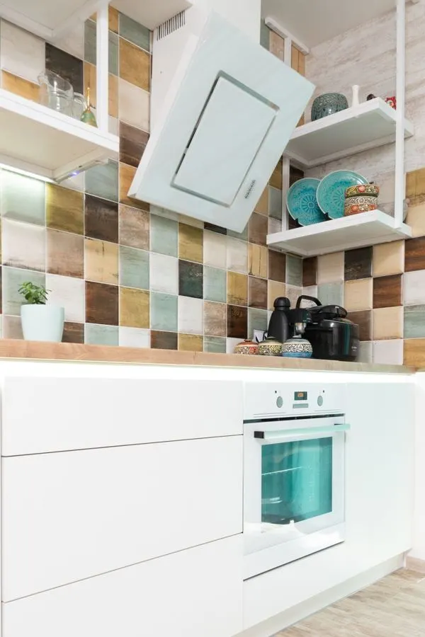 Multicoloured square kitchen backsplash with white cabinets