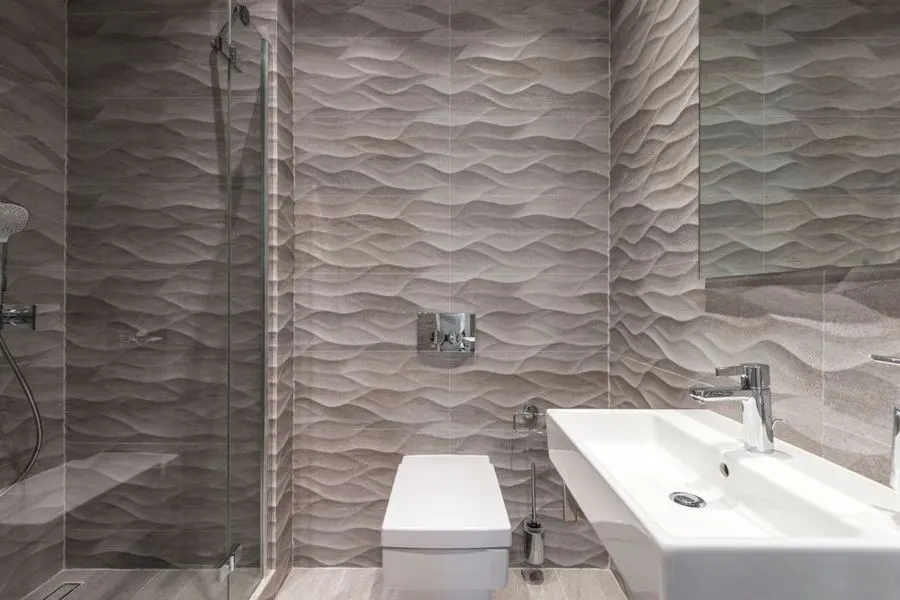 Bathroom with textured wave-pattern grey wall tiles