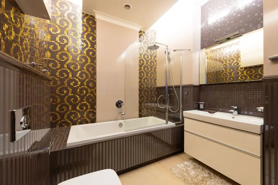 Bathroom with a bathtub and brown decorative wall tiles
